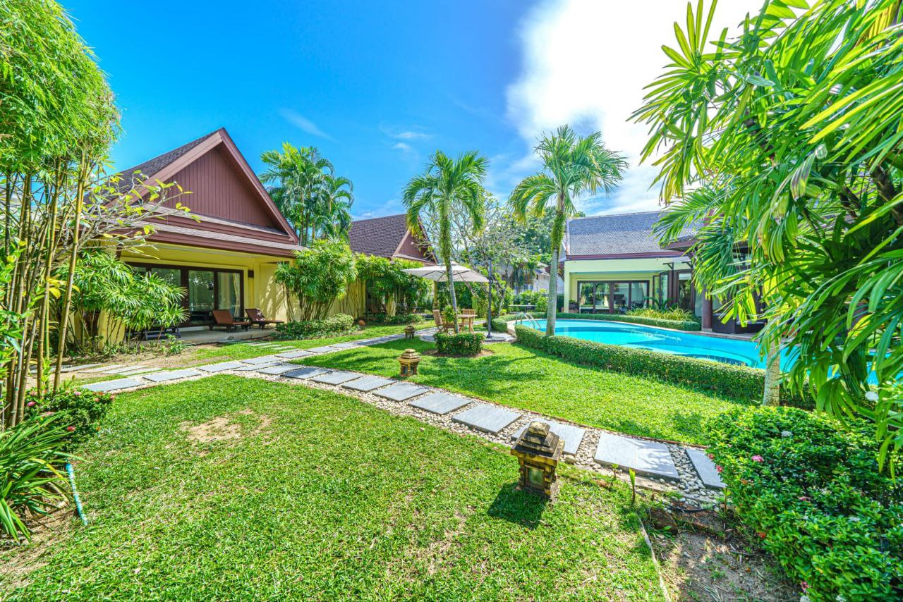 Lush tropical garden with swimming pool and villas at The Himmaphan Phuket.
